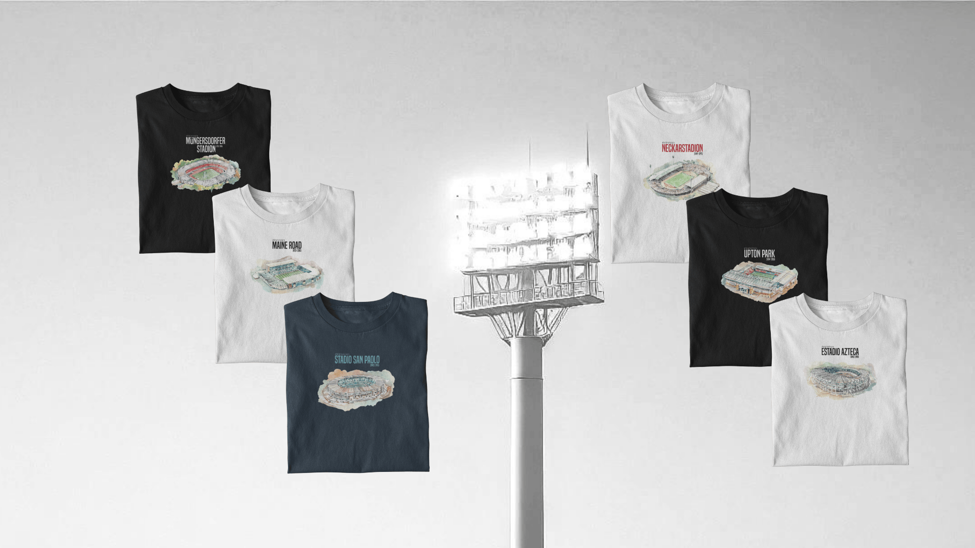 Verschieden farbige T-Shirts mit aufgedruckten legendären Fußballstadien. Ein Fluchtlicht im Hintergrund